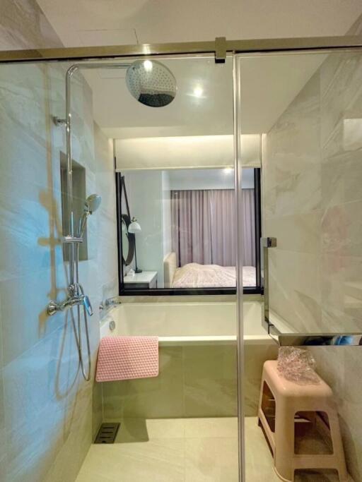 Modern bathroom with glass shower cabin overlooking bedroom