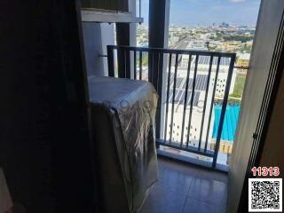 Small bedroom with a single bed and balcony access showing city view