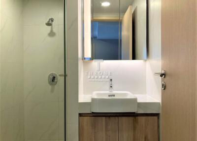 Modern bathroom with shower, sink, and mirror