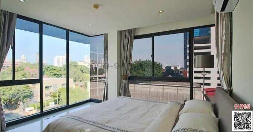 Spacious bedroom with large windows and city view