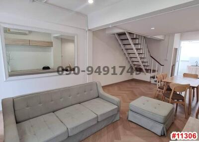 Spacious living room with modern couch and staircase