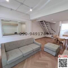 Spacious living room with modern couch and staircase