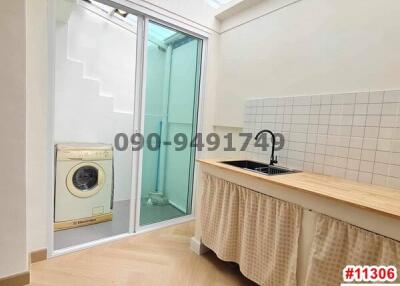 Compact laundry room with washing machine, skylight, and glass door leading to a small balcony