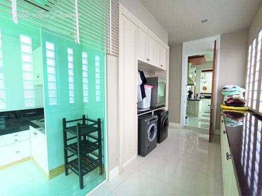 Compact laundry room with washer and dryer and built-in cabinets