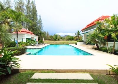 Swimming pool with surrounding garden and mountain view at a residential property