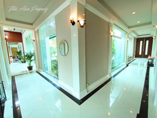 Spacious and luxurious lobby entrance with glossy tiled floors and elegant lighting