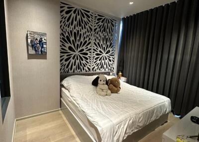 Modern bedroom with decorative wall and plush toys on the bed