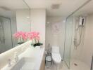 Modern bathroom with glass shower and decorative flowers