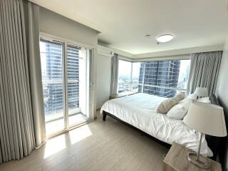 Spacious and well-lit bedroom with a large window and city view