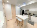 Modern kitchen with white cabinets, breakfast bar, and pendant lighting