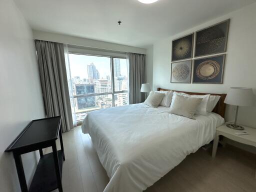 Spacious bedroom with large windows and city view