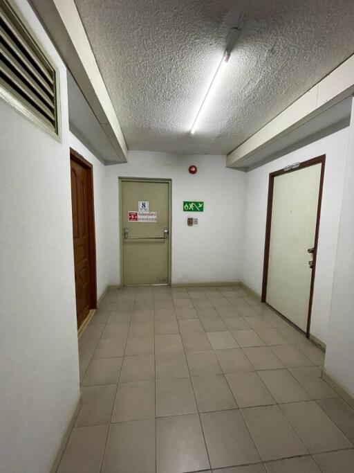Building hallway with exit signs and tile flooring