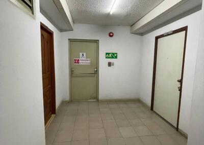 Building hallway with exit signs and tile flooring