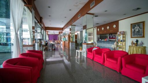 Spacious interior view of a building with red sofas and glossy floor