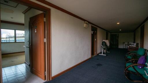 Spacious corridor leading to various rooms with exercise bike and sitting area