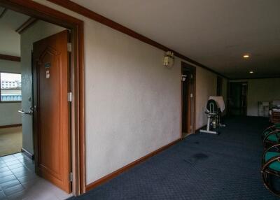 Spacious corridor leading to various rooms with exercise bike and sitting area