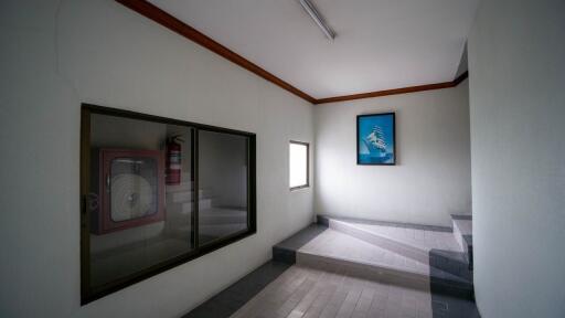 Spacious interior building hallway with steps leading to a higher level, ambient lighting, and artwork on walls