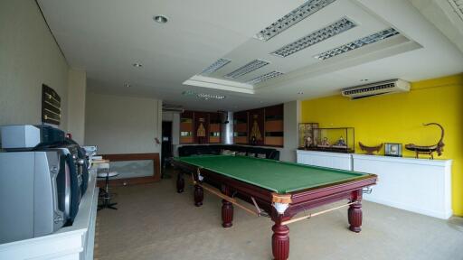 Spacious recreational room with billiard table and bright yellow walls