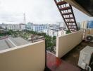 Spacious balcony with a city view and air conditioning unit