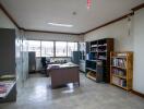 Spacious office room with large windows and bookshelves