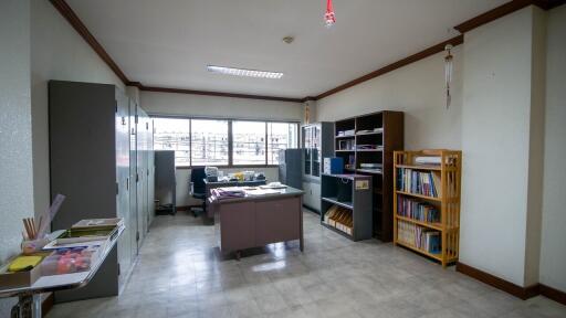 Spacious office room with large windows and bookshelves