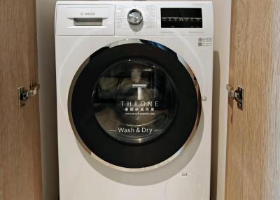 Compact Bosch washing machine installed in a wooden cabinet