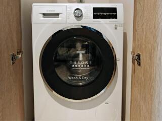 Compact Bosch washing machine installed in a wooden cabinet