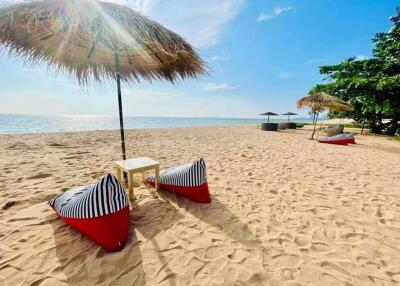 Relaxing beachfront with lounge chairs and umbrella on pristine sand