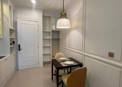 Modern kitchen with dining area, white cabinetry, and pendant lighting