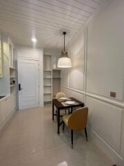 Modern kitchen with dining area, white cabinetry, and pendant lighting