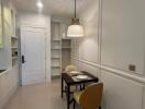 Modern kitchen with dining area, white cabinetry, and pendant lighting