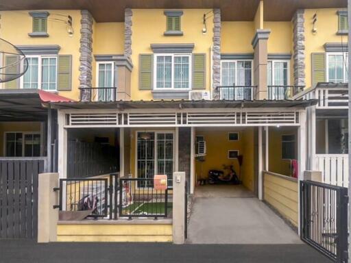 Exterior view of a residential building with car port and balcony