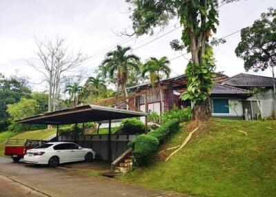 Suburban house with carport and lush greenery