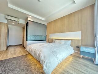 Spacious modern bedroom with a large bed and wooden accents