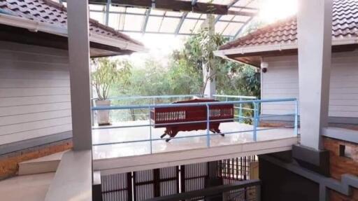 Bright and airy covered balcony with glass railing and outdoor furniture