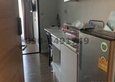 Compact modern kitchen with wood flooring and white cabinetry