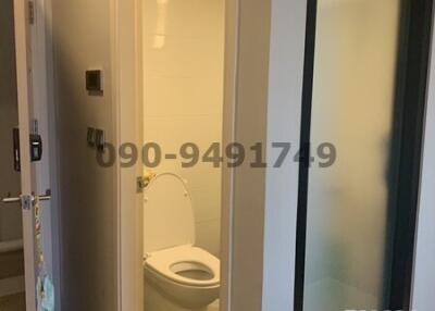 Compact bathroom with white fixtures viewed through open door