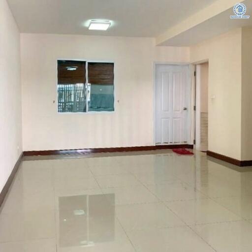 Spacious and well-lit empty room with glossy floor tiles