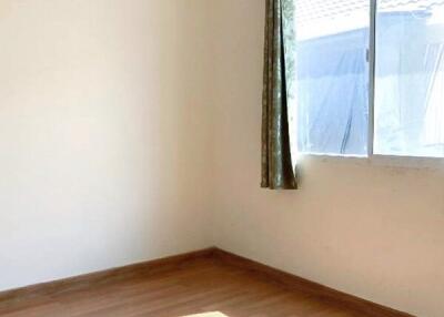 Empty bedroom with wooden floor and a large window