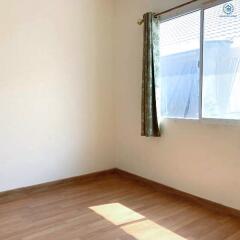 Empty bedroom with wooden floor and a large window