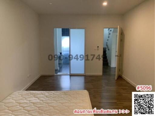Spacious bedroom with wooden flooring and large mirror
