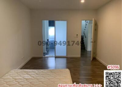 Spacious bedroom with wooden flooring and large mirror