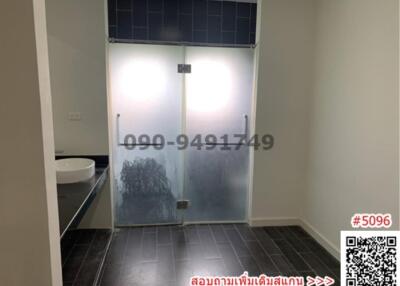 Modern bathroom with frosted glass shower doors and dark floor tiles