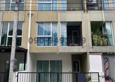 Modern three-story townhouse with glass balcony and secure entry gate