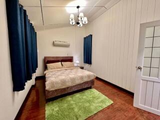 Cozy bedroom with wooden flooring and white panel walls