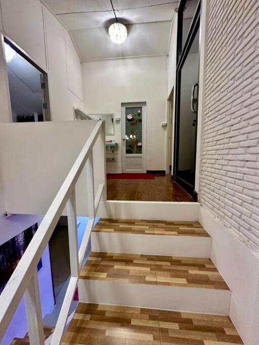 Bright hallway interior with wood flooring and stair access