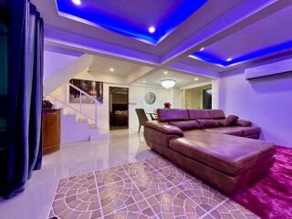 Modern spacious living room with LED ceiling lights and comfortable furnishings