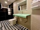 Modern bathroom with geometric floor tiles and a green countertop