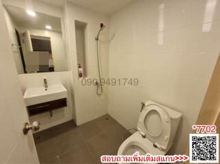 Modern bathroom with white fixtures and tiled walls