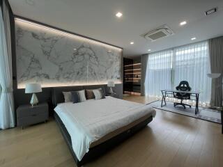 Spacious modern bedroom with large bed and artistic wall panel